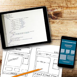 Website Wireframe Sketch And Programming Code On Digital Tablet